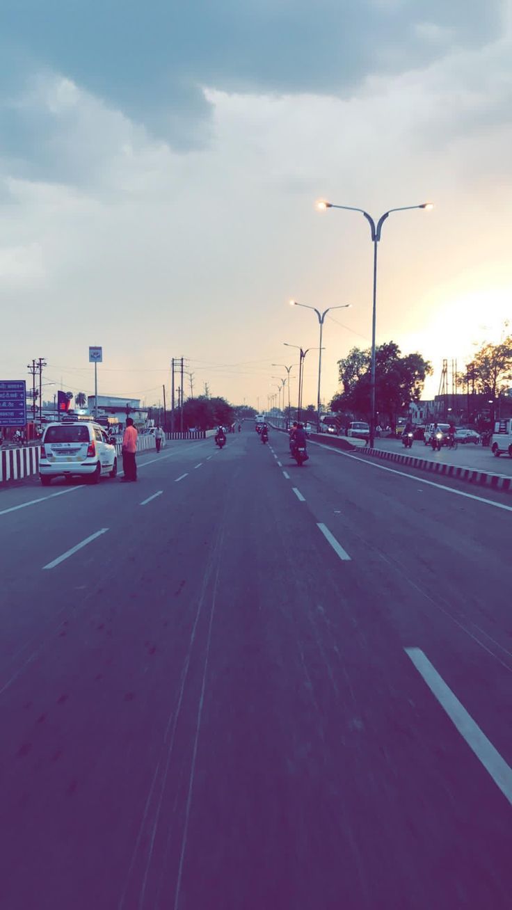 two police officers standing on the side of an empty highway at sunset or sunrise time