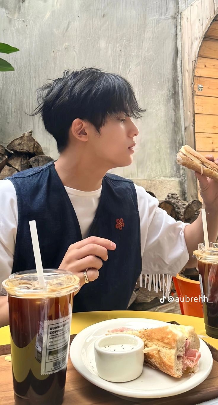 a person sitting at a table with food and drinks