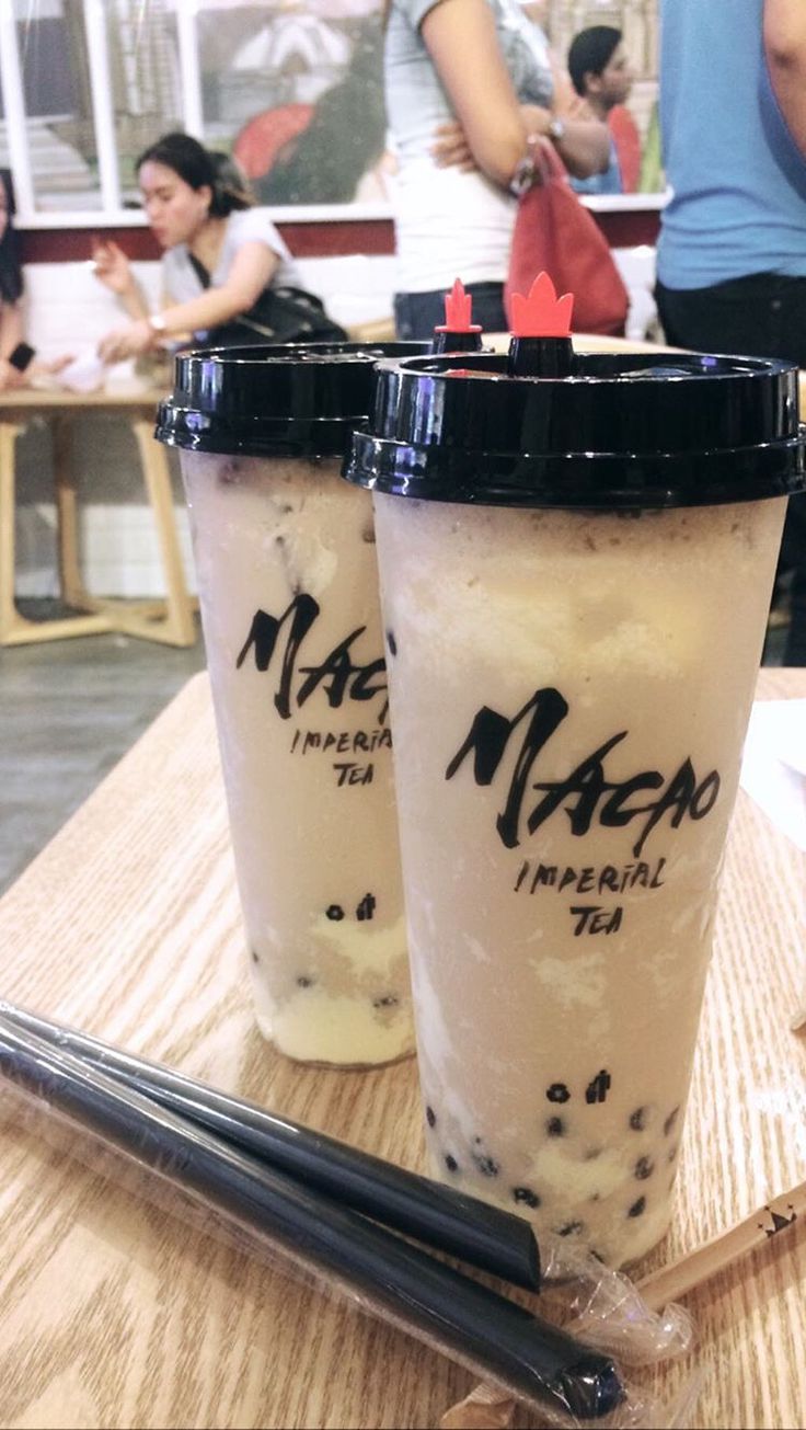 two iced drinks sitting on top of a wooden table