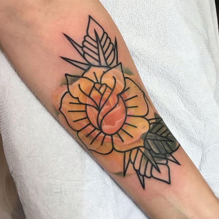 an orange flower tattoo on the left forearm and right arm, with black lines around it