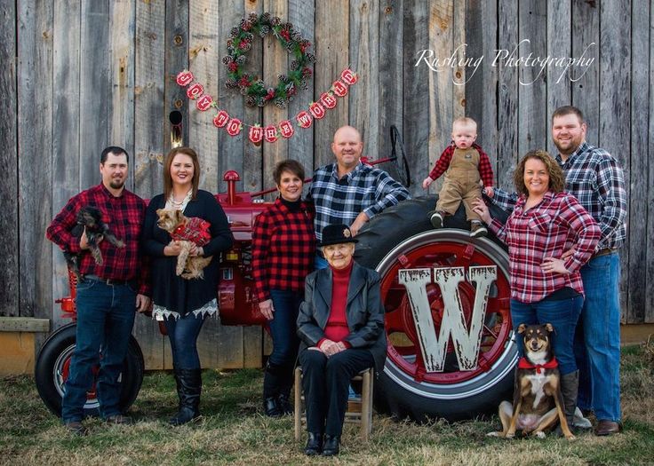 a family poses in front of a wooden fence for their christmas card photo with the letter w on it