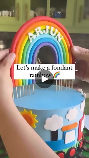 someone is decorating a cake with rainbow decorations on it and the words let's make a fondant rainbow