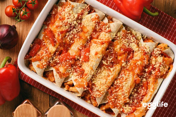 a casserole dish filled with pasta and sauce on top of a wooden table