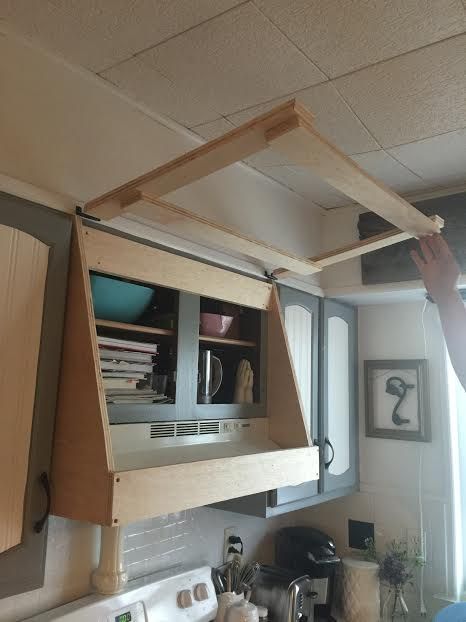 a man is fixing the ceiling in his kitchen