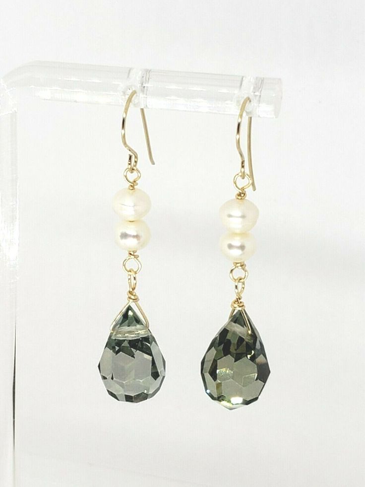 Elegant Gray Swarovski Crystal Teardrop Briolette and White Freshwater Pearl Drop Dangle Earrings  DETAILS: Metal:               Ear wires are 14k Solid Yellow Gold, wire is high quality 14k gold fill Style:                Drop / Dangle Length:             45mm/ 1 3/4" Total Weight:    3.34 grams Sone Details: Swarovski Briolette: 12.5x8mm Pearl: 4mm   Shipped with USPS First Class Package. We describe everything to the best of our knowledge, please look closely at all pictures as they are part Elegant Wire Wrapped Briolette Teardrop Earrings, Pearl Dangle Earrings, White Freshwater Pearl, Drop Dangle Earrings, Pearl Earrings Dangle, Emerald Jewelry, Gold Wire, Fine Jewellery Earrings, Pearl Drop