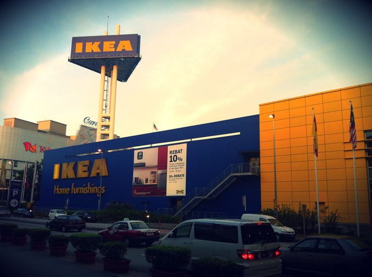 cars parked in front of a ikea store with a tall sign above it's entrance