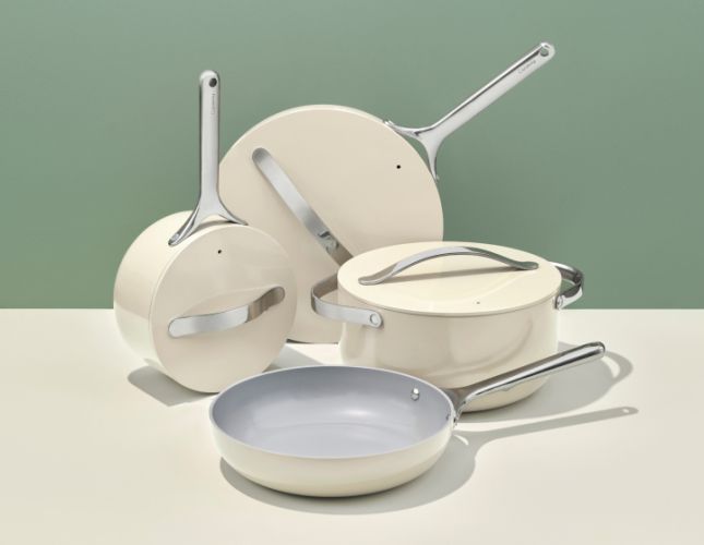 an assortment of white pots and pans on a table