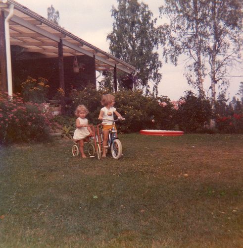 two children on bikes in front of a house