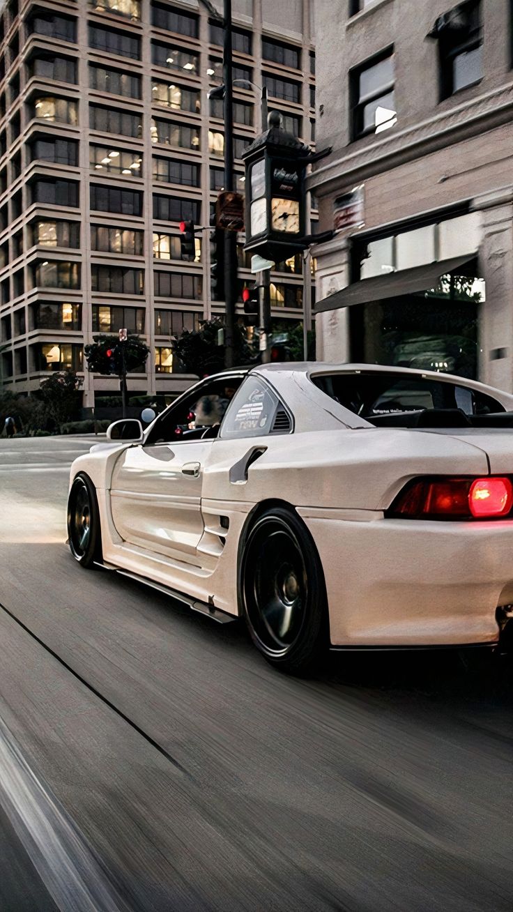 a white sports car driving down the street