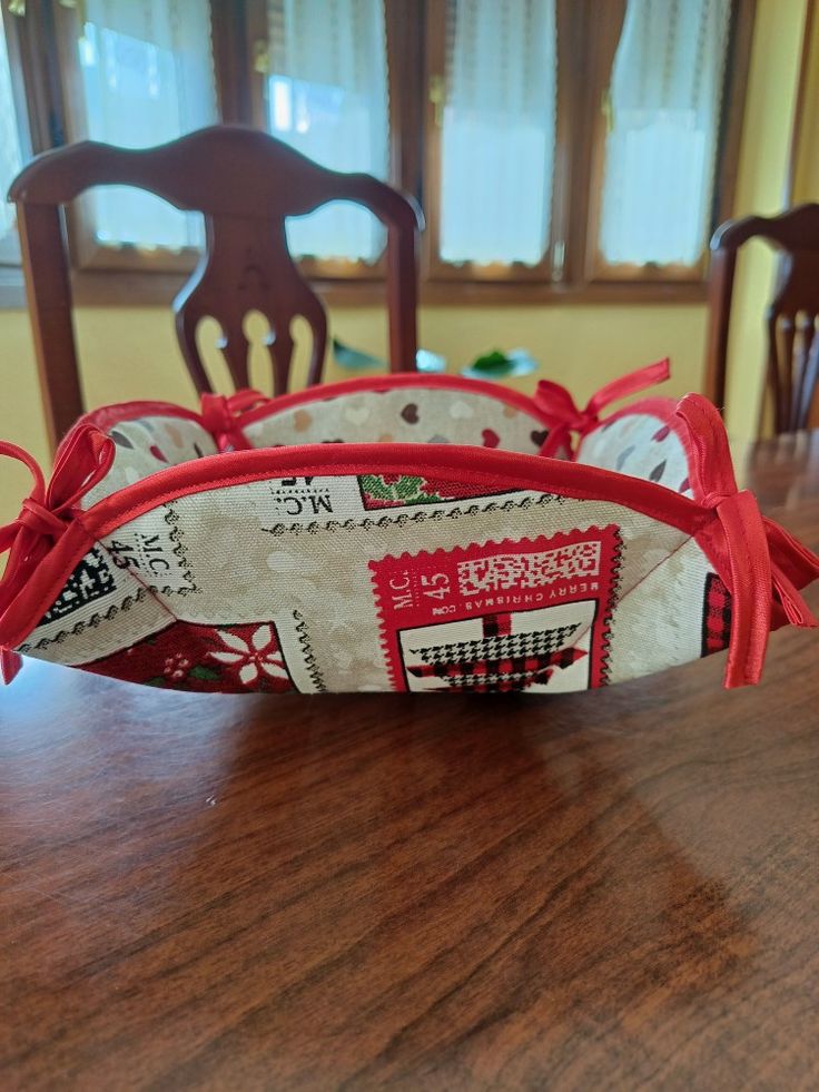 a wooden table topped with a basket filled with postage stamps and tied to it's sides