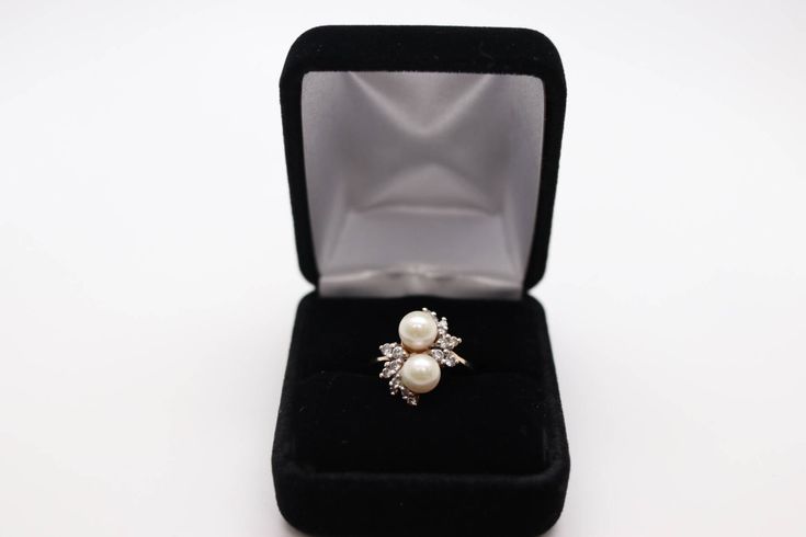 Stunning 14 karat yellow gold cocktail ring featuring two 6-1/2 mm diameter round white Akoya Cultured Pearls perfectly accented by 16 round diamonds .40 carats together. This ring is from a private estate collection and is in excellent, used condition. Size 6 1/2 ring Genuine Akoya Cultured Pearls Two 6-1/2 mm diameter round white Accent gems Genuine Diamonds Qty & cut: 16 round brilliant cut, estimated .40 carat together Clarity: SI-1 to SI-2 ColorL K - L Material: 14 karat yellow gold Mar Fine Jewelry Round Cut Pearl Ring For Anniversary, Pearl Ring With Prong Setting For Anniversary, Formal Brilliant Cut Pearl Ring, Fine Jewelry Brilliant Cut Pearl Ring For Anniversary, Classic White Bypass Ring For Formal Occasions, Classic White Evening Rings, Elegant 14k Gold Diamond Ring For Evening, Formal White Bypass Ring With Diamond Accents, Fine Jewelry Round Pearl Ring For Anniversary