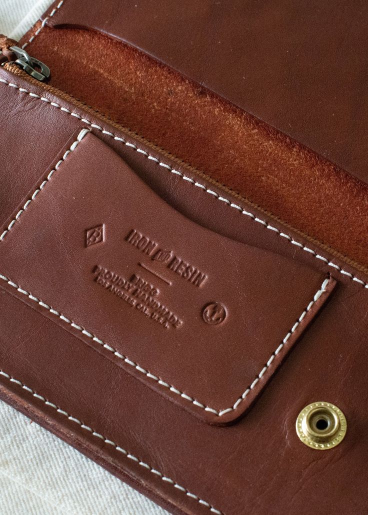 Our Brigg Leather Supply x Iron & Resin Roper Wallet is built for a lifetime of use. Made with a snap closure, a card slot, and a large zip pouch this wallet is ready for it all. Featuring a western inspired pattern and contrast stitching, this is a wallet that's not only functional but looks good doing it. THE SPECS + DETAILS 9-10oz USA Tanned Bridle Leather Traditional western wallet stylings One internal CC / ID slot Large zipper enclosed pouch Super durable nylon bonded threading with yoke s Brown Leather Wallet With Snap Closure, Brown Wallets With Snap Closure For Everyday Use, Brown Wallet With Snap Closure For Everyday Use, Vintage Wallet With Coin Pocket For Everyday Use, Bifold Coin Purse With Snap Closure, Vintage Everyday Wallet With Coin Pocket, Travel Bifold Coin Purse With Snap Closure, Brown Leather Wallet On Chain With Card Slots, Brown Bifold Coin Purse With Snap Closure