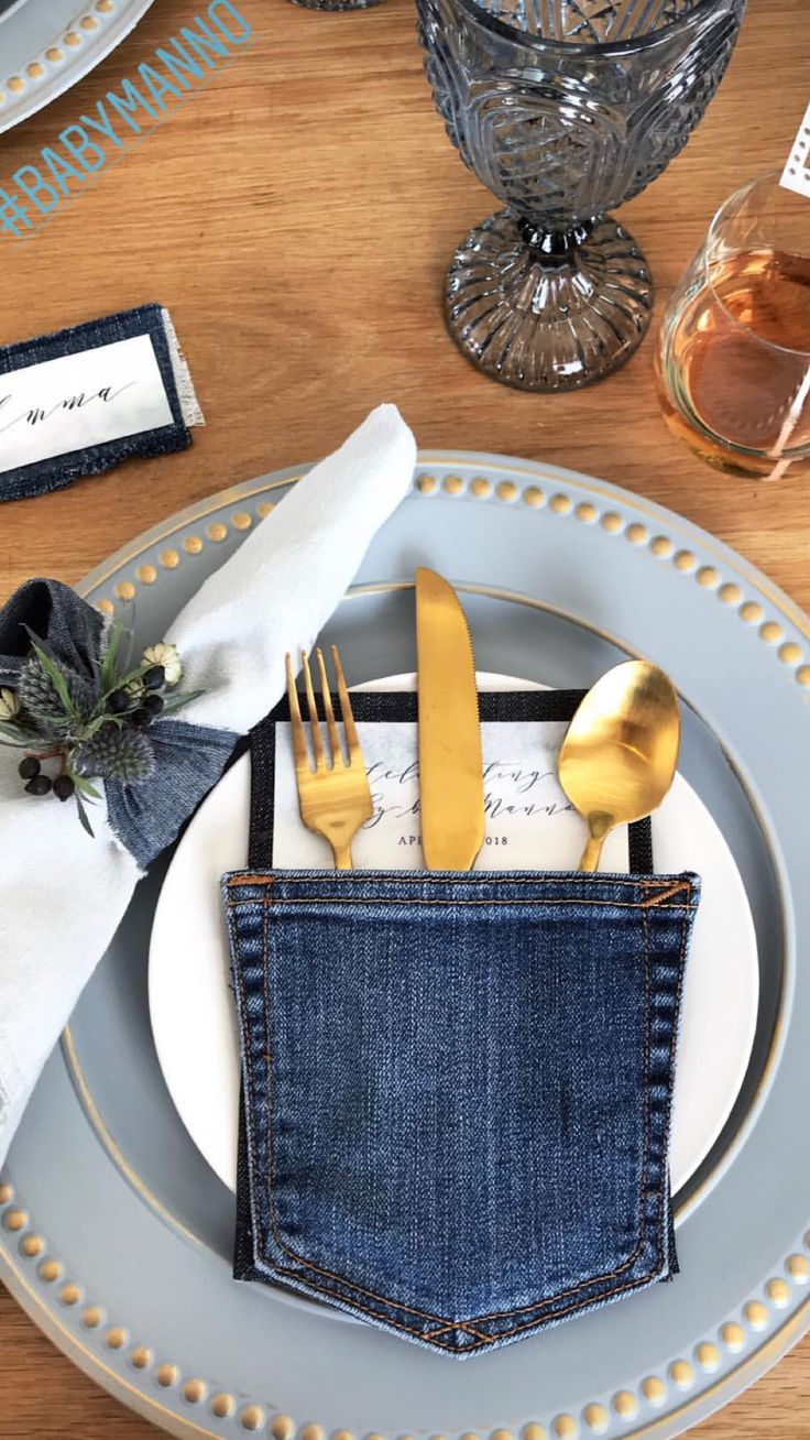 a place setting with silverware, napkins and gold utensils in a pocket