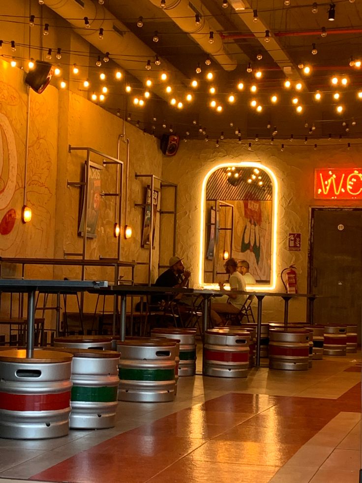 the inside of a restaurant with barrels and lights