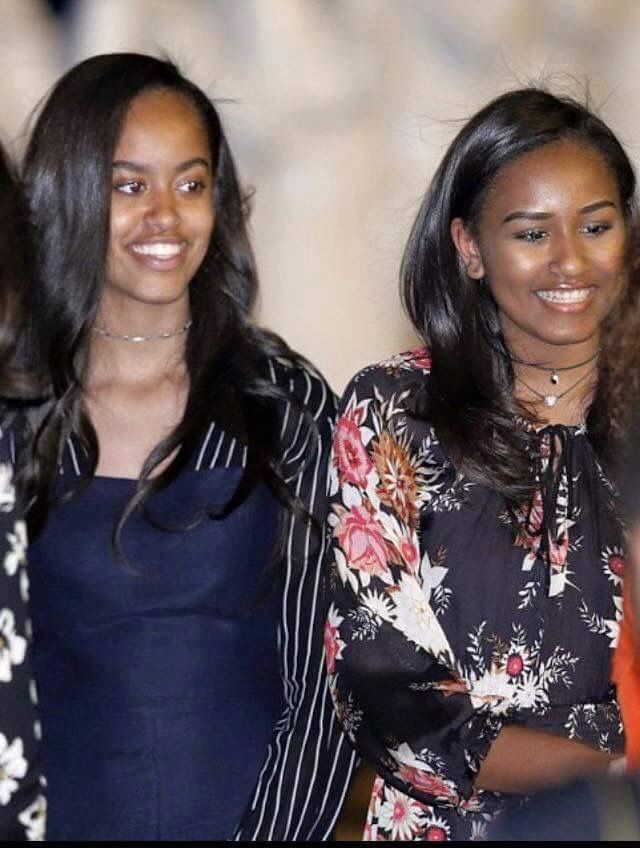 two women standing next to each other smiling for the camera with another woman in the background