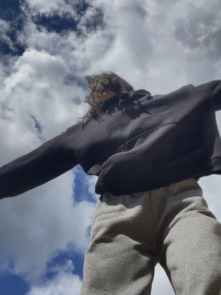 a person standing in front of some clouds