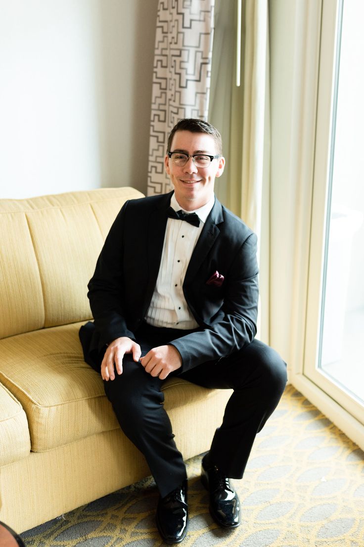 a man in a tuxedo sitting on a couch