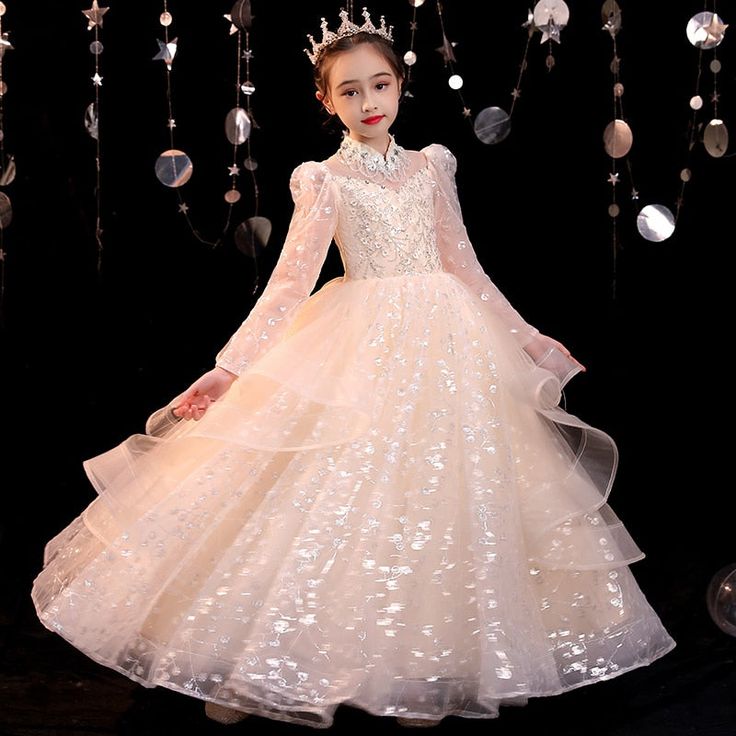 Mesmerize the crowd in this rare design Elegant Sequin Long Sleeve Layer Skirt Gown. Specially tailored for your little girl's special moment to shine! A light-weight quality formal gown that's guaranteed comfortable to the skin. Features: Sequined floral design appliques. Puff-sleeve style design. Turtle neck collar design. Ankle-length ball gown. Comfortable light-weight fashion gown. Fabric & Care: Made of high-quality polyester & voile fabric. Dry cleaning preferred. Do not bleach. Size Char Princess Style Floor-length Dress For Pageant, Princess Style Floor-length Pageant Dress, Holiday Ball Gown For Dress-up, Elegant Long Sleeve Ball Gown For Dress-up, Elegant Ball Gown Princess Dress For Formal Occasions, Elegant Formal Princess Ball Gown Dress, Princess Style Ball Gown For Formal Occasions, Fitted Princess Pageant Dress Floor-length, Fitted Princess Style Floor-length Pageant Dress