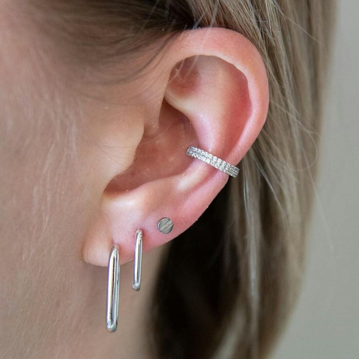 a woman's ear is shown with two silver bars attached to it