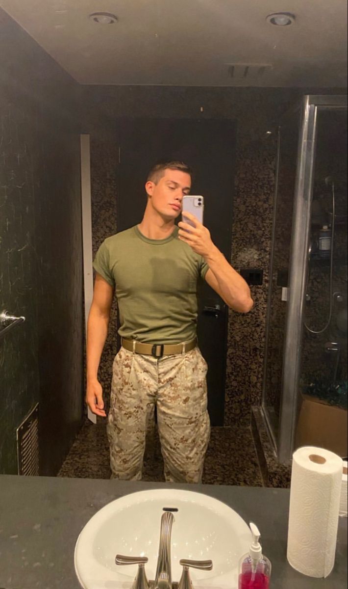 a man taking a selfie in front of a bathroom mirror while holding a cell phone