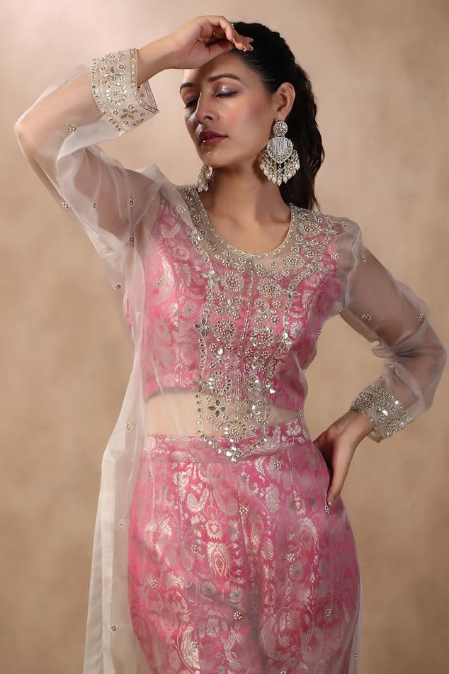 Ivory semi-sheer kurta with floral hand Embroidery. Comes with floral pattern pink brocade pant and crop top.
Components: 3
Pattern: Hand Embroidered
Type Of Work: Gota Patti, Pearls
Neckline: Round
Sleeve Type: Full
Fabric: Kurta: Organza, Pant and Crop Top: Pink
Color: Pink,White
Other Details: 
Attached lining
Approximate product weight: 0.5-1 kg
Occasion: Mehendi and Haldi - Aza Fashions Sheer Kurta, Pink Brocade, Floral Hand Embroidery, Pink Kurta, Crop Top Pink, Pant Set, Set For Women, Aza Fashion, Fashion Set