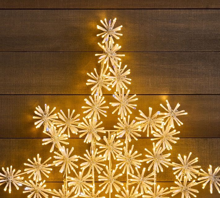 a christmas tree made out of snowflakes sitting on top of a wooden table