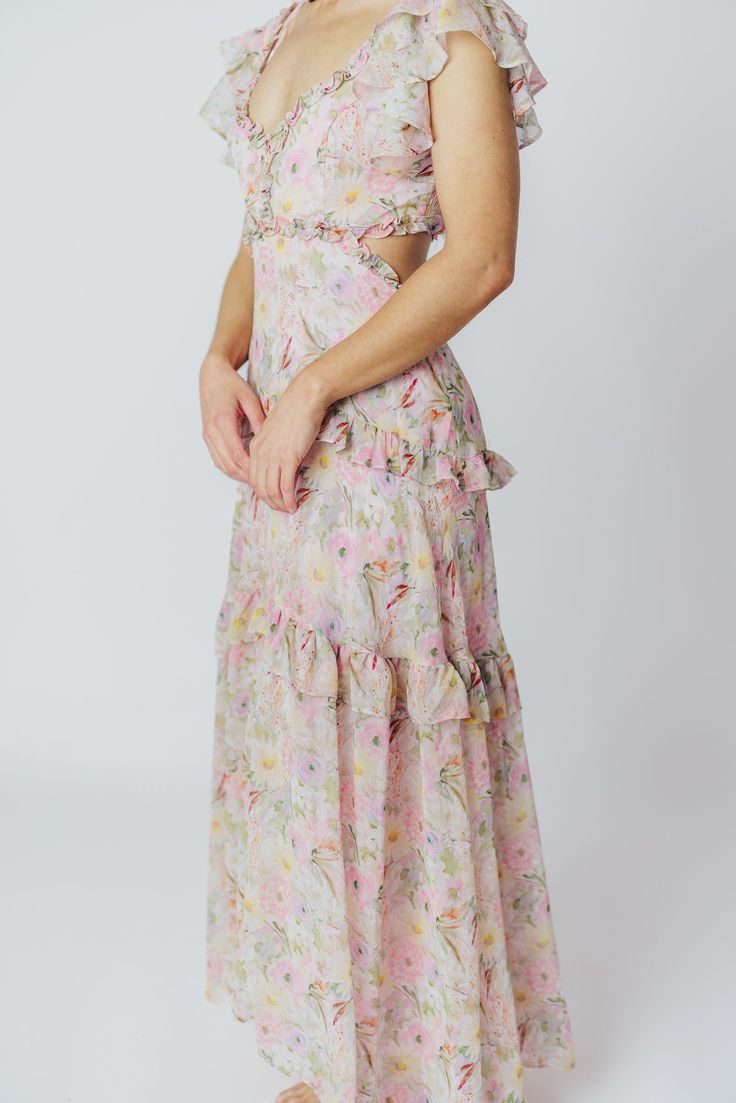 We think the gorgeous Millie Maxi Dress from ASTR is fit for a princess. It's all flowers and ruffles and utterly romantic, perfect for a special vacation dinner, or for when you want to RSVP "elegant" to a spring wedding or shower. This dress doesn't skimp on the feminine details, and deserves a place of honor in your closet! FIT: Runs true to size. Bust is fitted, with a low neckline and bodice cut-outs. MATERIAL: GARMENT DETAILS: Floral chiffon maxi dress, with a plunging V-neckline, multi-tiered ruffled sleeves, and side cut-outs under the bust. Features a full, flowy skirt with ruffle accents, a smocked back panel, and a back self-tie detail at the shoulders. SIZE GUIDE: XS (00-0) / S (2-4) / M (6-8) / L (10-12) MODEL DETAILS: ﻿Heather is wearing size S. Mackenzie - Size S Heather - S Spring Garden Party Ruffle Dress With Ruffled Straps, Flirty Ruffle Hem Maxi Dress For Garden Party, Flirty Maxi Dress With Ruffle Hem For Garden Party, Ruffled Dresses For Vacation Garden Party, Flirty Dresses With Ruffled Straps For Garden Party, Feminine Ruffled Maxi Dress For Garden Party, Feminine Maxi Dress With Ruffled Skirt For Garden Party, Fitted Floral Print Maxi Length Ruffle Dress, Feminine Ruffle Hem Dress For Garden Party