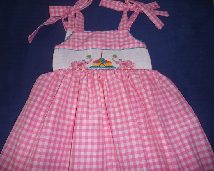 Hand smocked summer dress with pink elephants and circus. Ties at the shoulders and back. This could be a birthday dress. For other sizes allow 3 tweeks Playful Pink Dress With Smocked Back, Playful Summer Smocked Dress, Playful Summer Smocked Dress With Smocked Back, Playful Smocked Dress With Smocked Bodice For Summer, Playful Pink Smocked Dress With Ruffles, Pink Smocked Dress For Playtime In Summer, Pink Smocked Dress For Summer Playtime, Playful Pink Dress With Smocked Bodice, Cute Pink Smocked Dress With Smocked Back