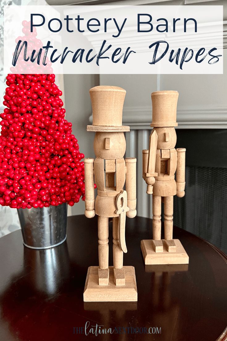 two wooden nutcrackers sitting on top of a table next to a christmas tree