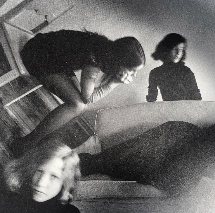 black and white photograph of two women on a bed with one woman leaning over the edge