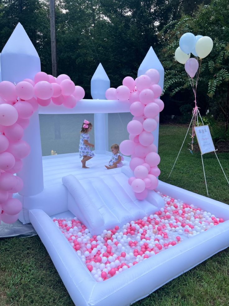 an inflatable castle with pink and white balloons