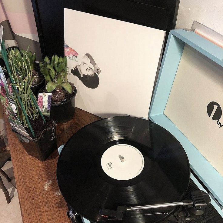 a record player sitting on top of a wooden table next to a box with a picture