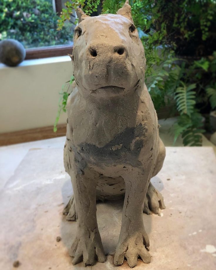 a statue of a hippopotamus sitting on top of a table