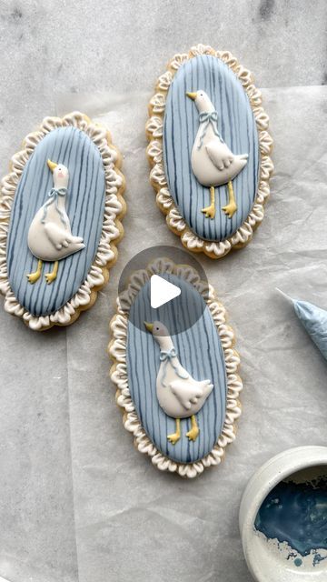 three decorated cookies sitting on top of a table