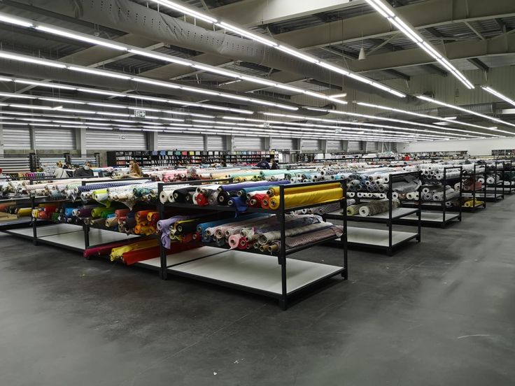 an empty warehouse filled with lots of different types of fabrics and blankets on shelving