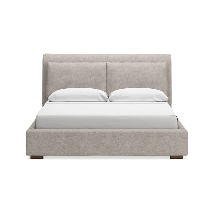 an upholstered bed with white sheets and pillows