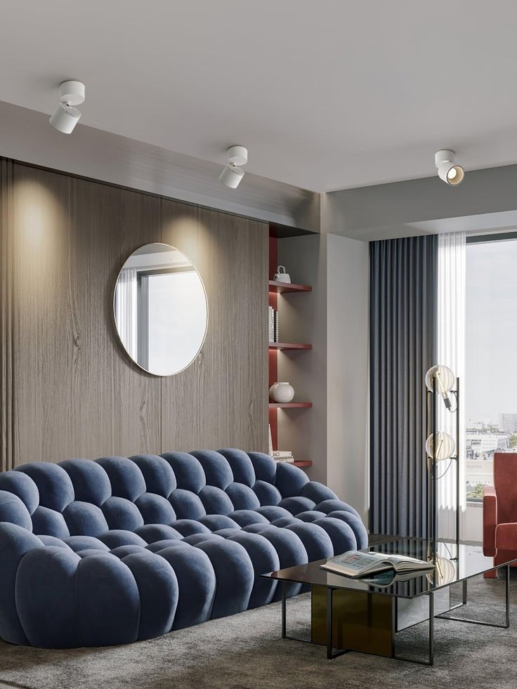 a living room filled with furniture and a round mirror on the wall above it's headboard