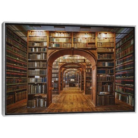 the inside of a library with many bookshelves and lights on each side of the room