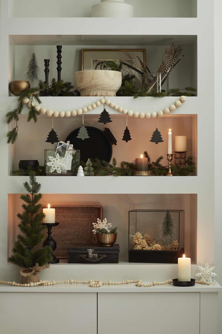 christmas decorations are displayed on shelves in the living room, with candles and other items