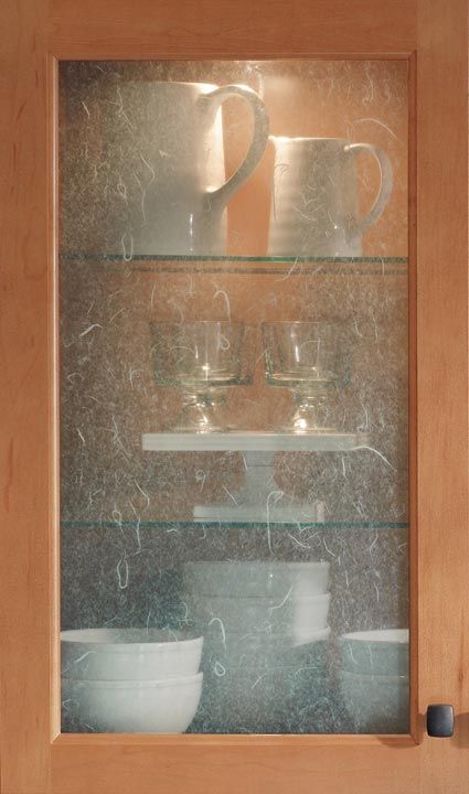 a wooden cabinet with glass shelves filled with dishes and cups on it's sides