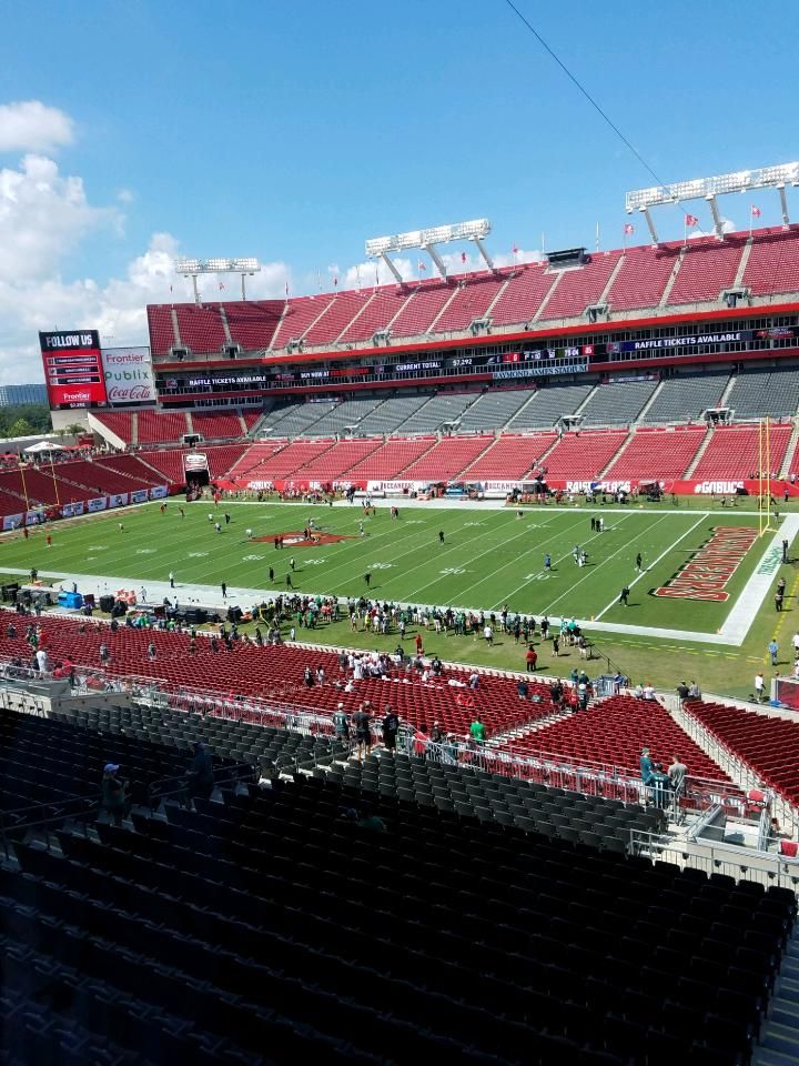 an empty stadium filled with people on the field during a football game in red and white