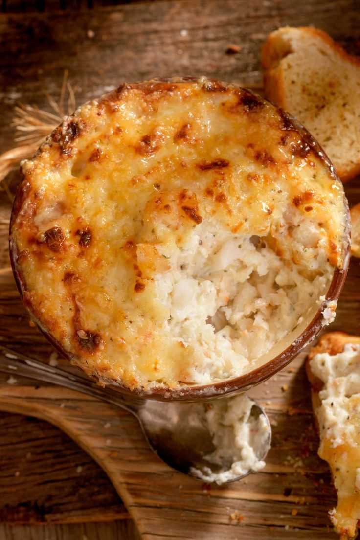 a bowl filled with macaroni and cheese next to slices of bread