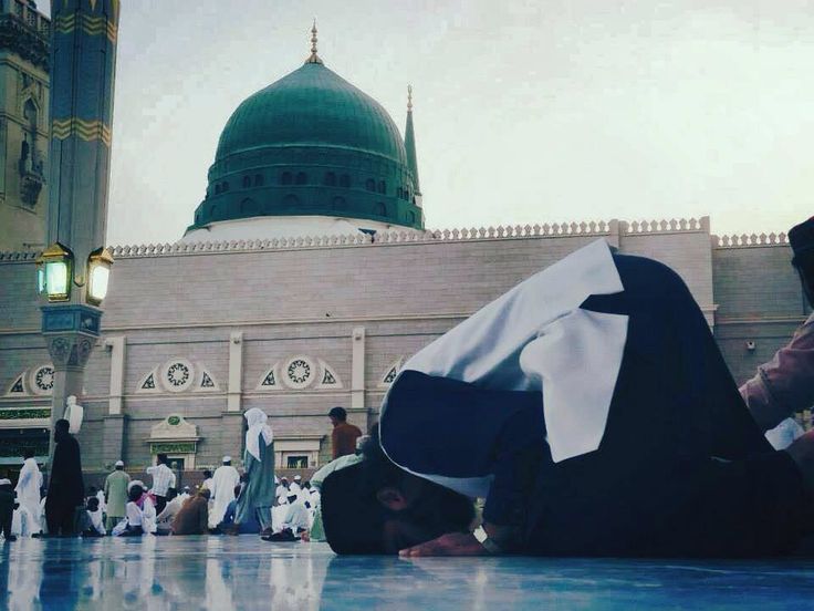 a person laying on the ground in front of a building with a green dome above it