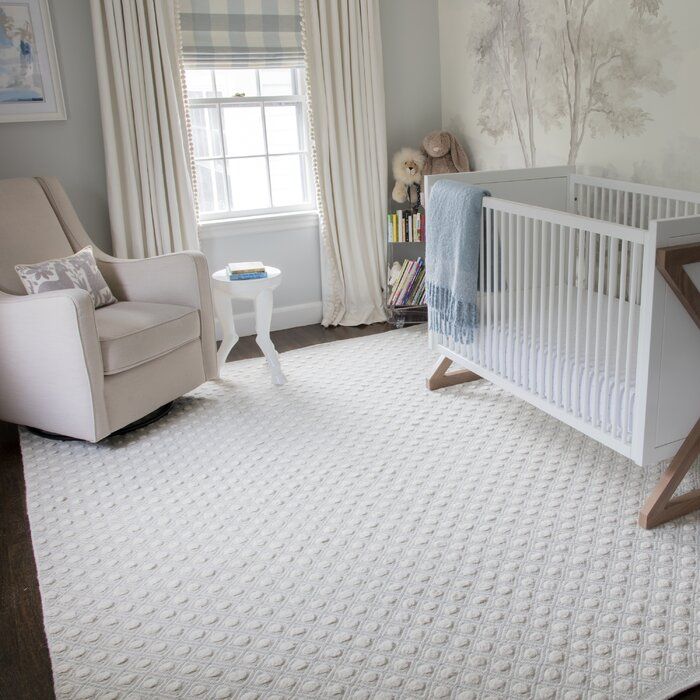 a baby's room with a crib, chair and window