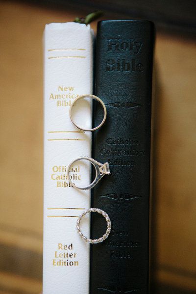 two wedding rings sitting on top of a book next to an open ring binder