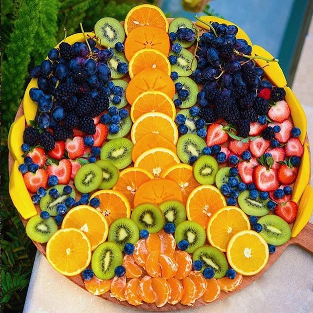 a platter filled with lots of fruit on top of a table