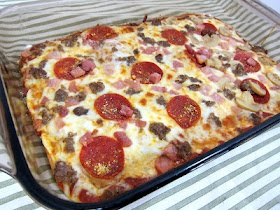 a square pizza with pepperoni, sausage and cheese in a pan on a table