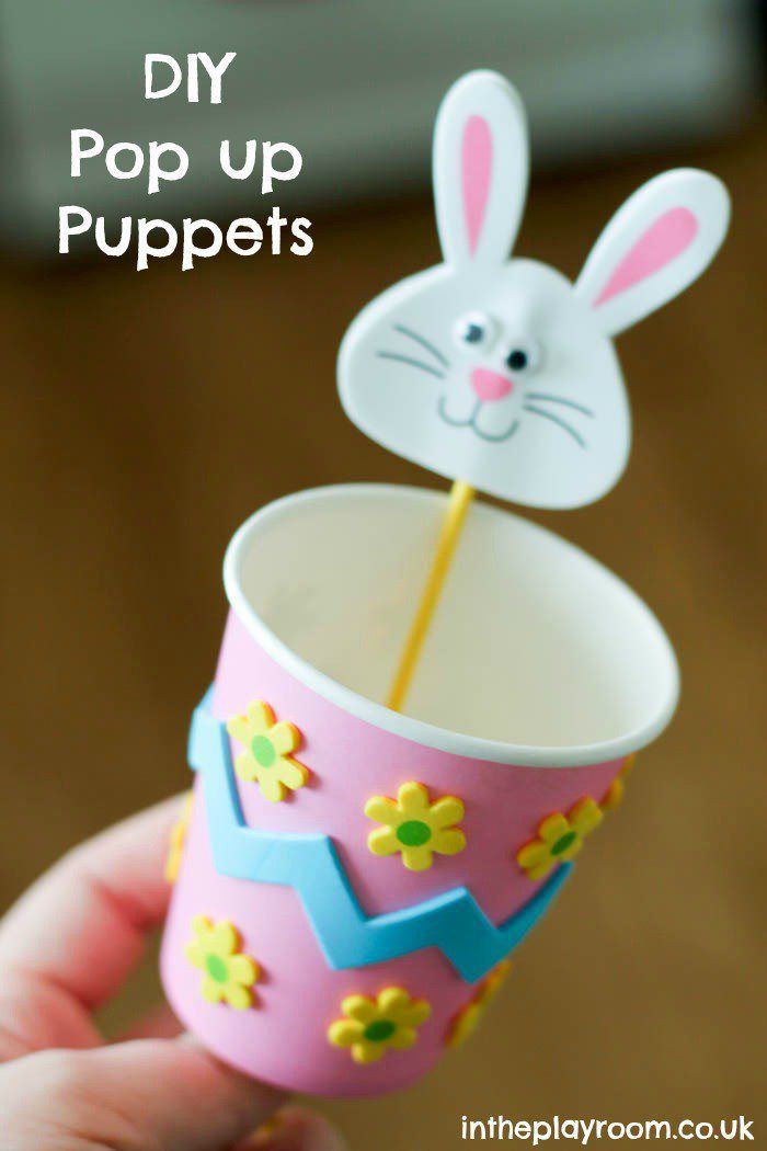 a hand holding a paper cup with an easter bunny sticking out of it