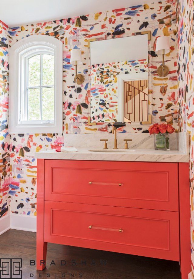 a bathroom with colorful wallpaper and an orange vanity in front of a white window