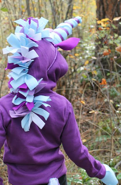 a young child wearing a purple and blue costume with horns on it's head